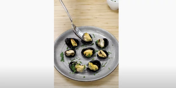 Screen shot of the video of Chef Sabrina plating her mussel chips in a composed dish.