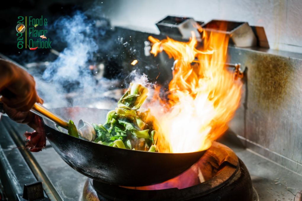 Street food chef cooking over high flames, reflecting how street food influences the food world.
