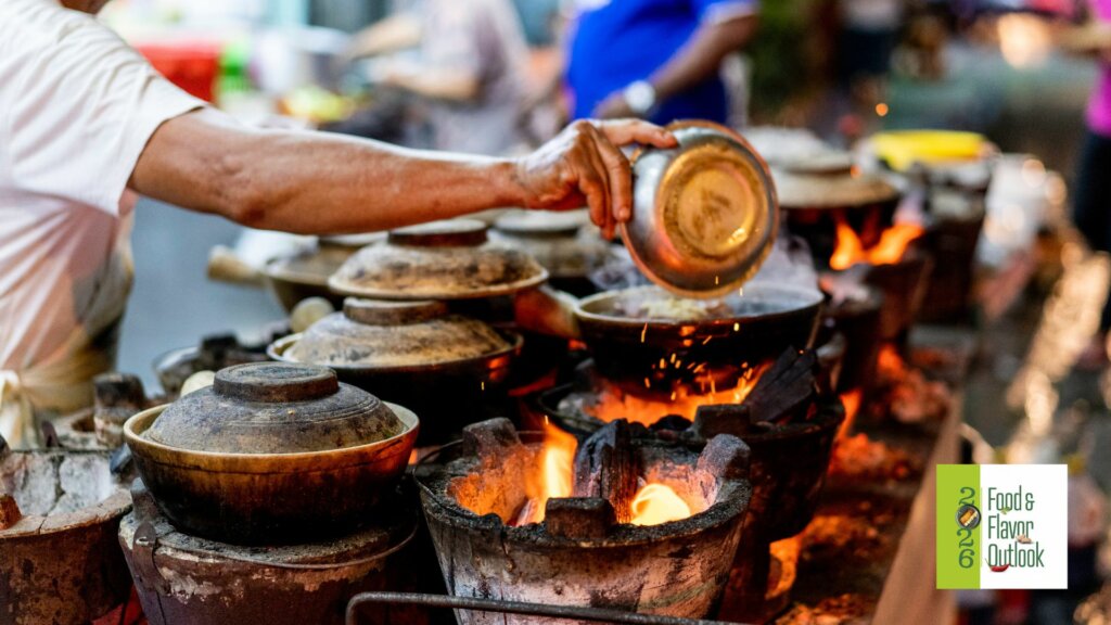 Street food vendor cooking over hot coals at a busy outdoor market, highlighting the bold flavors of the Street food culture.