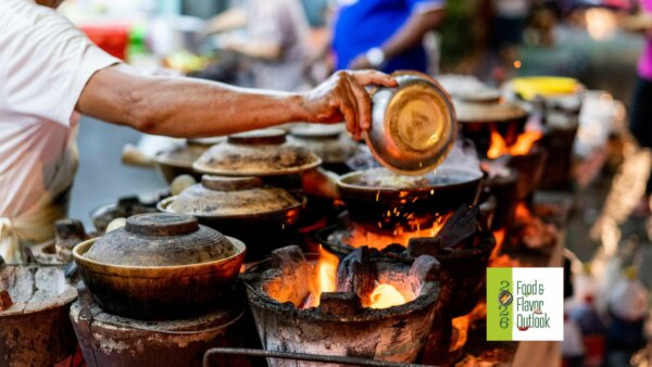 Street food vendor cooking over hot coals at a busy outdoor market, highlighting the bold flavors of the Street food culture.