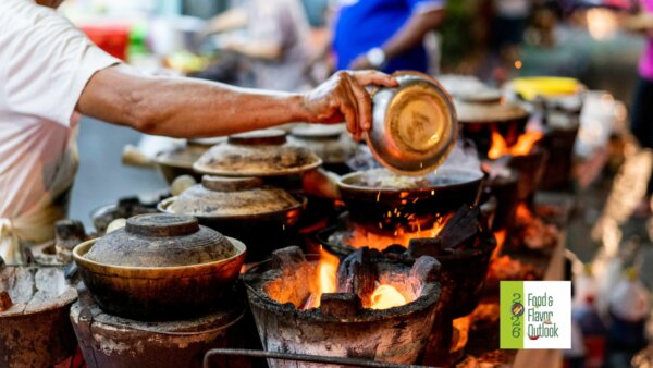 Street food vendor cooking over hot coals at a busy outdoor market, highlighting the bold flavors of the Street food culture.