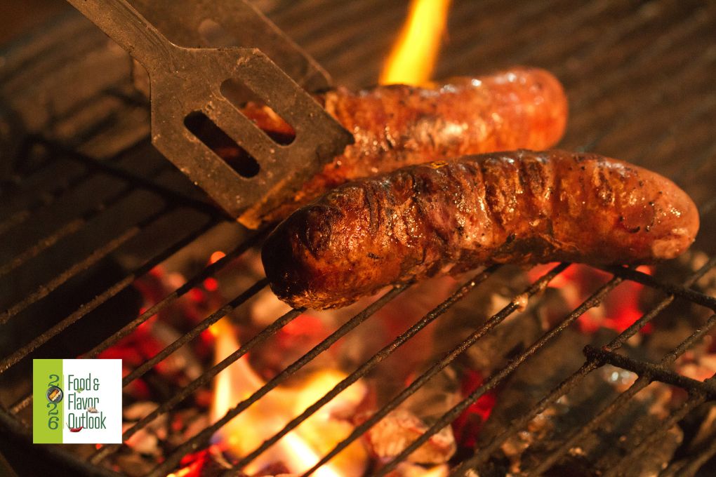 Grilled sausage cooking over an open flame on a barbecue grill, highlighting the smoky, charred flavors and rustic cooking techniques used in street food.