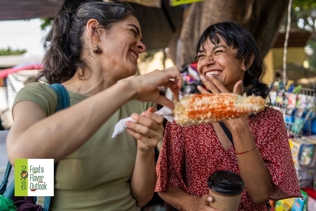 Friends enjoying food at an outdoor market, highlighting how consumers are seeking flavorful, social, and experience driven dining moments beyond just taste. 