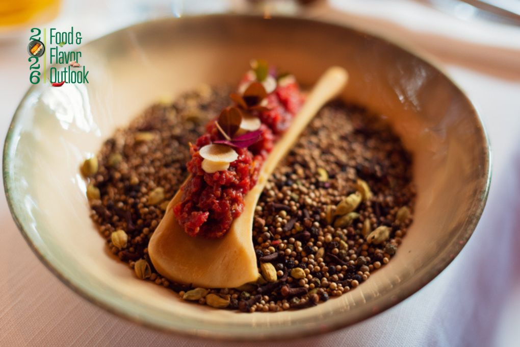 Bowl of beef tartare topped with seasoning and served on a bone, representing bold, layered flavors.