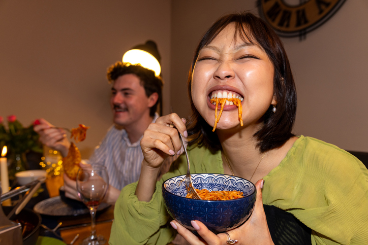Women enjoying a bowl of noodles, representing the experience of layered flavors in homemade dishes.