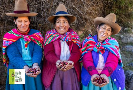 Three women in traditional clothing holding traditional ingredients, highlighting the connection between traditional foods, culture, and nutrition.