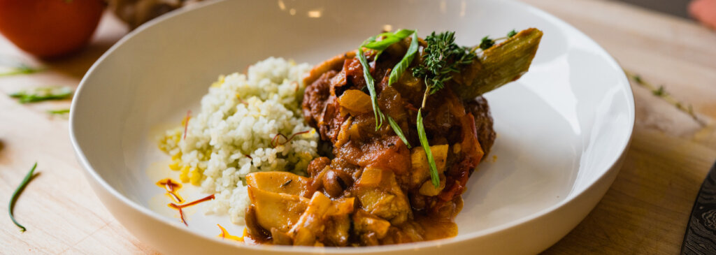 A plate of plant-based protein with rice, garnished with basil and saffron.